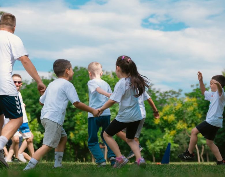 Group of children having fun and playing games together in a sunny park.